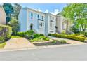 A view of the townhome's exterior shows lush landscaping and a driveway leading to the garage at 3688 E Bay St, Duluth, GA 30096
