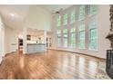 An open-concept living room with hardwood floors, a stone fireplace, and tall windows at 3801 Bays Ferry Trl, Marietta, GA 30062