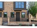 Street view of a townhome with brick facade, dark accents, tidy landscaping, and a modern design at 1122 W Marietta St, Atlanta, GA 30318