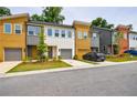 Exterior street view of modern townhomes showcasing colorful exteriors and attached garages at 1624 Gunnin Nw Trce, Atlanta, GA 30318