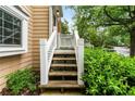 Cozy home entrance featuring white banisters, green foliage and wooden steps leading to the front door at 3019 Camden Way, Alpharetta, GA 30005