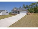 Attractive single-story home with a long concrete driveway, gray siding, and a neatly landscaped front yard at 707 Ralph Still Rd, Dacula, GA 30019