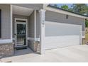 Close-up of the front entrance and garage, highlighting the gray siding and brick accents of the home at 707 Ralph Still Rd, Dacula, GA 30019