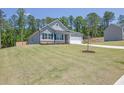 Well-maintained single-story home with gray siding, a two-car garage, and a lush, green front yard at 707 Ralph Still Rd, Dacula, GA 30019