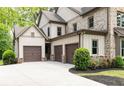 Three-car garage with brick and siding exterior and manicured landscaping at 610 Valley Green Trce, Marietta, GA 30068