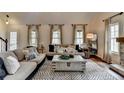 Cozy living room features neutral tones, patterned rug, and three windows inviting natural light at 443 Lakeshore Dr, Berkeley Lake, GA 30096