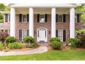 Up close image showing brick exterior, columns, trimmed shrubs, and front door at 295 Glen Lake Dr, Atlanta, GA 30327