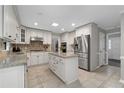 Well-lit kitchen with white cabinetry, stainless steel appliances, granite countertops, and tiled flooring at 411 Woodstone West Dr, Marietta, GA 30068