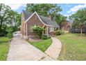 Cozy brick home with a curved roofline, arched entryway, detached garage, and driveway at 1791 Melrose Sw Dr, Atlanta, GA 30310