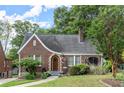 Charming brick home with a curved roofline, arched entryway, and lush landscaping at 1791 Melrose Sw Dr, Atlanta, GA 30310