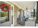 Inviting front porch with stone accents, brick floor, comfortable seating, and a decorative wreath at 429 Nickajack Retreat Se Ln, Smyrna, GA 30082