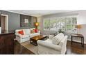 Bright living room with hardwood floors, large windows with plantation shutters, and comfortable furnishings at 3005 Howell Mill Rd, Atlanta, GA 30327