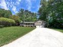 Traditional home with a well-manicured lawn, front porch, and long driveway leading to a two-car garage at 3075 Nuthatch Nw Ct, Kennesaw, GA 30144