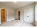 Neutral toned bedroom with plush carpet, ensuite door and double closets at 1907 Deco Dr, Kennesaw, GA 30144