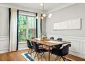Bright dining room with modern lighting, a wooden table set for six, and large window with serene backyard view at 732 Province Se Pl, Atlanta, GA 30312