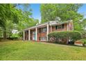 Two-story brick home featuring a manicured lawn, white columns, and a classic, timeless aesthetic at 1426 Diamond Head Dr, Decatur, GA 30033