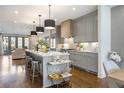 Open kitchen with island, pendant lighting, grey cabinets, stainless appliances, and hardwood floors at 726 Edgewood Ne Ave, Atlanta, GA 30307