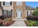 Inviting front entrance with a white door, stone accents, and colorful flower bushes at 113 Glenmore Ln, Mcdonough, GA 30253