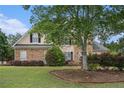 Charming two-story home featuring a brick facade, lush landscaping, and a well-manicured lawn at 113 Glenmore Ln, Mcdonough, GA 30253
