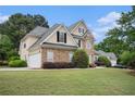 Lovely two-story home with a stone facade, lush landscaping, and attached two-car garage at 113 Glenmore Ln, Mcdonough, GA 30253
