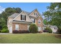 Beautiful two-story home with a stone facade, manicured lawn, and attached two-car garage at 113 Glenmore Ln, Mcdonough, GA 30253