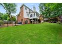 Spacious backyard featuring a well-kept lawn, privacy fence, and an outdoor lounge at 1703 Brandywine Ct, Atlanta, GA 30338