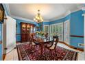 Elegant dining room featuring a large window, chandelier, and custom china cabinet at 1703 Brandywine Ct, Atlanta, GA 30338