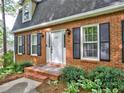 Up close view of the brick facade of a home, showcasing black shutters and a manicured landscape at 1257 Independence Way, Marietta, GA 30062