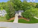 An aerial view showcases this charming home with mature trees and a well-maintained lawn at 1405 Arden Trace Ln, Lawrenceville, GA 30043