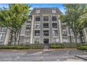 Beautiful condo building exterior with balconies, secure gate, and lush green landscaping at 2657 Lenox Ne Rd # C38, Atlanta, GA 30324