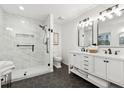 Modern bathroom featuring a walk-in shower with marble tile, a double sink vanity, and black accents at 650 Hunterhill Ct, Roswell, GA 30075