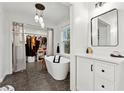 Bathroom with closet, featuring a freestanding tub, modern vanity, and stylish lighting at 650 Hunterhill Ct, Roswell, GA 30075
