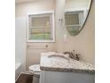 Bathroom featuring a granite vanity top, decorative mirror and tiled wall at 4004 Knightsbridge Nw Rd, Kennesaw, GA 30144