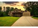 Charming two-story home with a covered front porch and a well-manicured lawn and driveway at 547 Ellington Rd, Oxford, GA 30054