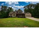 Charming two-story home with a covered front porch and a well-manicured lawn at 547 Ellington Rd, Oxford, GA 30054
