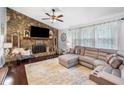 Open living room with stone fireplace, plush seating, and large windows for natural light at 1965 Stilesboro Nw Dr, Kennesaw, GA 30152