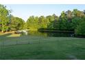 Picturesque pond surrounded by mature trees and lush greenery, enhancing the property's natural beauty at 4076 Airline, Mcdonough, GA 30252
