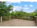 Expansive wooden deck with a scenic view of lush green trees and a bright blue sky at 472 Rigby Ne St, Marietta, GA 30060