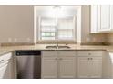 Kitchen with stainless steel dishwasher, white cabinets, granite countertops, and window view at 6416 Vicksburg Nw Ct, Acworth, GA 30101
