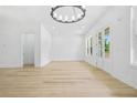 Bright living room with a modern chandelier, hardwood floors, and large windows overlooking the greenery outside at 225 Alcovy Cir, Covington, GA 30014
