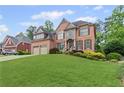 Charming brick two-story home with a lush green lawn and a convenient two-car garage at 3341 Cranmore Chase, Marietta, GA 30066