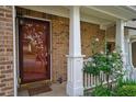 Welcoming front entrance featuring a stylish door, brickwork, and a charming rose bush at 589 Fox Creek Xing, Woodstock, GA 30188