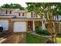 Inviting townhouse showcasing brick and siding, complete with an attached garage and well-maintained landscaping at 589 Fox Creek Xing, Woodstock, GA 30188