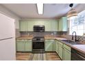 Stylish kitchen featuring mint-green cabinets, stainless steel appliances, and butcher block countertops at 589 Fox Creek Xing, Woodstock, GA 30188