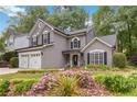 Charming two-story home featuring a two-car garage, manicured lawn and flower garden at 2849 Beddington Way, Suwanee, GA 30024