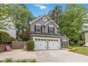 Charming two-story home featuring a two-car garage, with mature trees and landscaping at 2849 Beddington Way, Suwanee, GA 30024