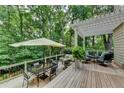 Inviting outdoor deck with a pergola, patio furniture, and views of the wooded surroundings at 3265 Bentwood Close, Cumming, GA 30041