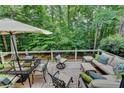 Inviting outdoor deck with comfortable patio seating, a glass dining table, and a shaded umbrella at 3265 Bentwood Close, Cumming, GA 30041