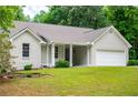 Charming single-story home featuring an attached garage, landscaped yard, and covered entry at 9691 Squirrel Wood Run, Douglasville, GA 30135