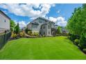 Expansive backyard with lush green grass, manicured landscaping, and a black iron fence at 3755 Valleyway Rd, Cumming, GA 30040